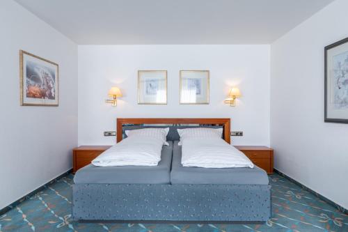 バート・エーンハウゼンにあるHotel Wittekindsquelleの枕2つが備わるドミトリールームのベッド1台分です。