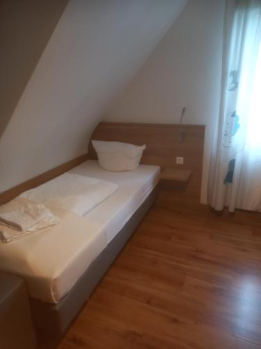 ein kleines Bett in einem Zimmer mit Fenster in der Unterkunft Hotel Krone Bad Cannstatt in Stuttgart