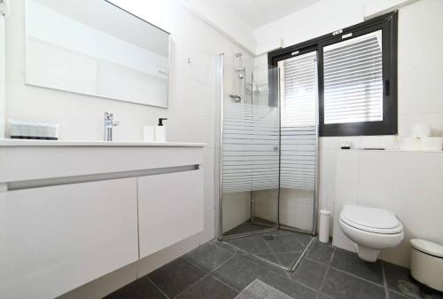 Baño blanco con aseo y lavamanos en L.T.D- MY VIEW. 2 bedroom apartment by the lake., en Tiberíades