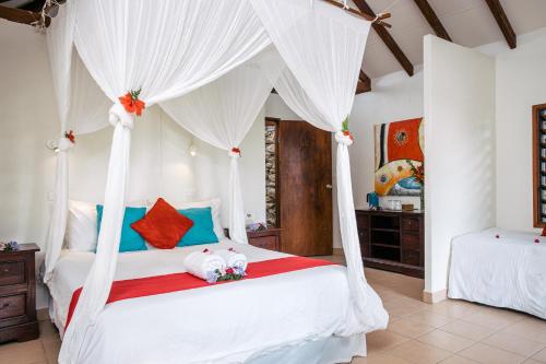 um quarto com uma cama de dossel branca com animais de peluche em Coco Beach Resort em Port Vila