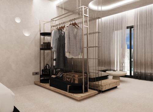 a bathroom with a rack of clothes and a toilet at Brilliance of Mykonos in Glastros