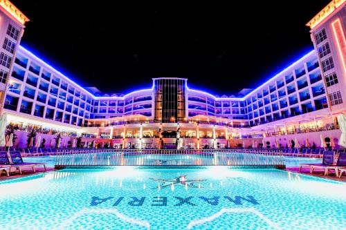 un grande edificio con una grande piscina di notte di Maxeria Blue Didyma a Didim