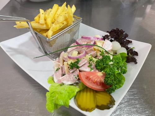 a plate of food with a salad and french fries at Hotel Hahnenblick in Engelberg