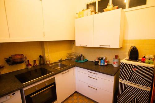 a kitchen with white cabinets and a black and white refrigerator at Jolie chambre dans appartement cosy en plein centre in Marseille