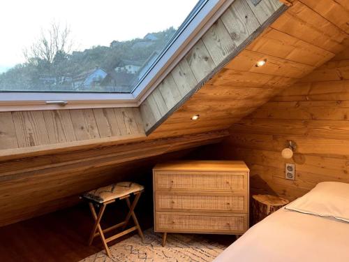 a bedroom in a log cabin with a bed and a window at Splendide appartement style chalet classé 4 étoiles, terrasse face à la montagne in La Bresse