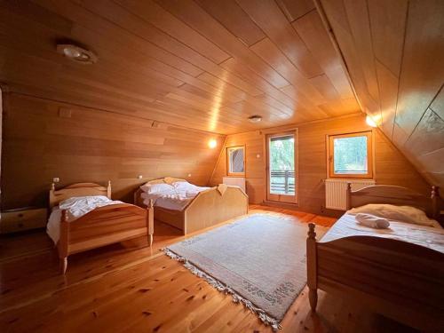a room with two beds in a wooden room at Planinska Koliba Vlašić in Vlasic