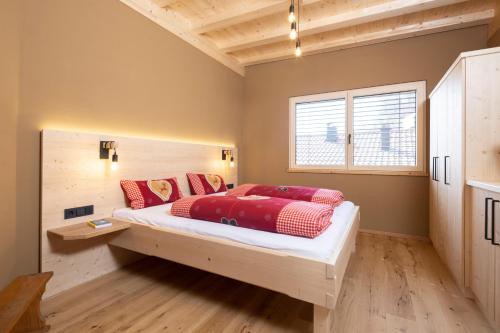 a bedroom with a large bed with red pillows at Bio-Chalet Haus Wagner in Niederndorf