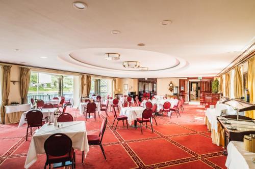 a restaurant with tables and chairs in a room at Rheinhotel Schulz in Unkel