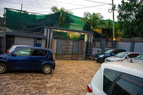 a small blue car parked in front of a building at Secure cozy getaway near Kampala business district in Kampala