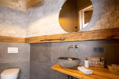 ein Bad mit einem Waschbecken und einem Spiegel in der Unterkunft Bio-Chalet Haus Wagner in Niederndorf