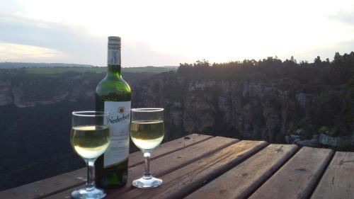 a bottle of wine and two glasses on a wooden table at The Farmers Lodge in Thorndale