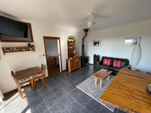 a living room with a couch and a table at Tunnel Ridge Outlook in Mooloolah