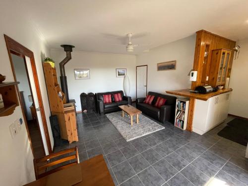sala de estar con sofá y mesa en Tunnel Ridge Outlook, en Mooloolah