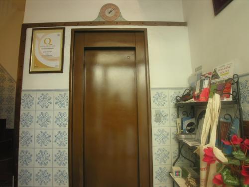 a wooden door in a room with a clock on the wall at Hotel Toledo in Naples