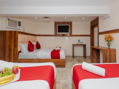 a hotel room with two beds with a plate of food at Hotel KGN - Mumbai in Mumbai