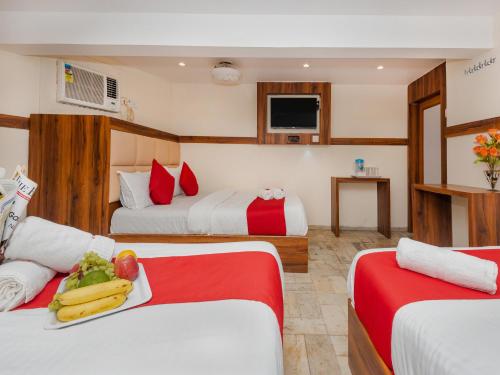 um quarto de hotel com duas camas com fruta numa bandeja em Hotel KGN - Mumbai em Mumbai