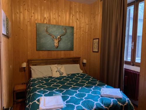 - une chambre avec un lit avec une tête de cerf sur le mur dans l'établissement Villa Tancredi, à Courmayeur