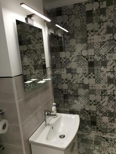 La salle de bains est pourvue d'un lavabo et d'un miroir. dans l'établissement Modern Studio, à Târgu-Mureş