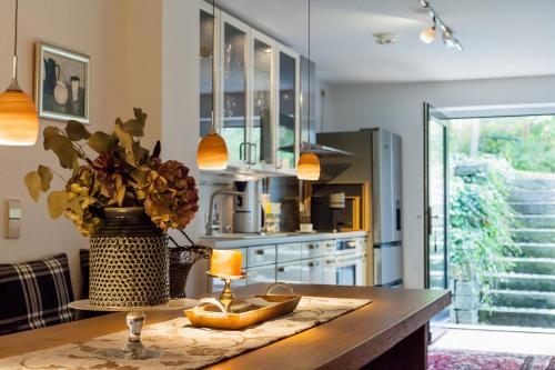 a kitchen with a table with a lamp and a vase of flowers at Hotel Zur Linde Dein Self Check In in Michendorf
