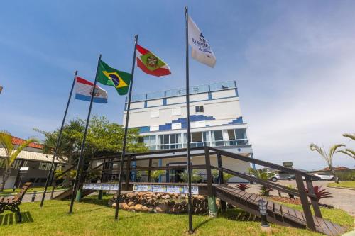 a group of flags in front of a building at Hotel Bandeirantes da Barra in Balneario Barra do Sul