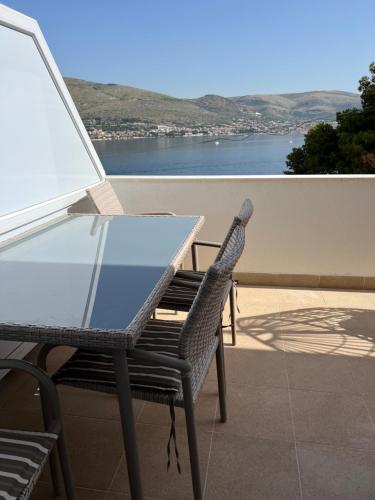 d'une table et d'une chaise en verre sur un balcon avec vue. dans l'établissement apartment Julija, à Okrug Donji