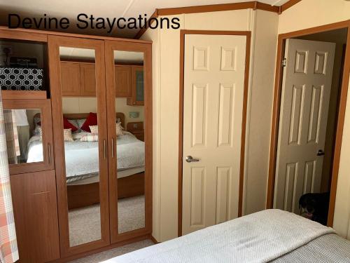 a room with a bedroom with a bed and two doors at Devine Staycations at 38 Riverside in Hawick