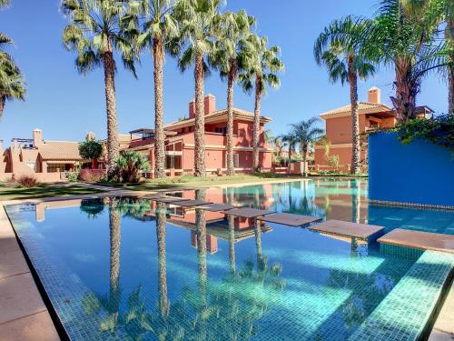 a swimming pool with palm trees in front of a house at Arona 2 - 5907 in Mar de Cristal