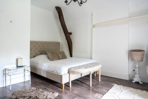 a bedroom with a white bed with a table and a window at Chateau des Ayes - Chambres & suites in Saint-Étienne-de-Saint-Geoirs