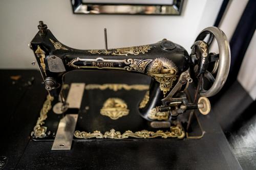 a black and gold sewing machine sitting on a table at Chateau des Ayes - Chambres & suites in Saint-Étienne-de-Saint-Geoirs