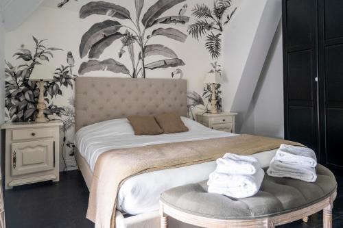 a bedroom with a bed with plants on the wall at Chateau des Ayes - Chambres & suites in Saint-Étienne-de-Saint-Geoirs