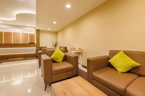 a waiting room with brown leather chairs and a table at Hotel Comfort Park - Opposite Sri Ramachandra Medical College Porur in Chennai