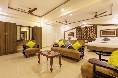 una camera d'albergo con letto, divano e sedie di Hotel Comfort Park - Opposite Sri Ramachandra Medical College Porur a Chennai