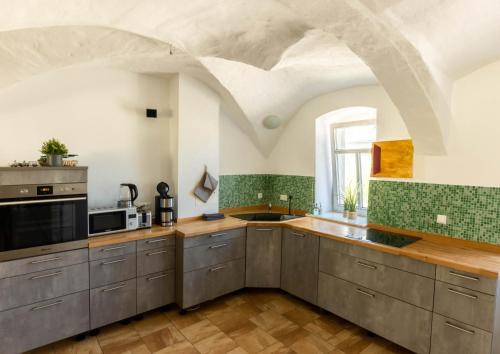 a kitchen with gray cabinets and green tiles at Gewölbe aus dem Jahr 1806 genau zw L und DD in Mügeln