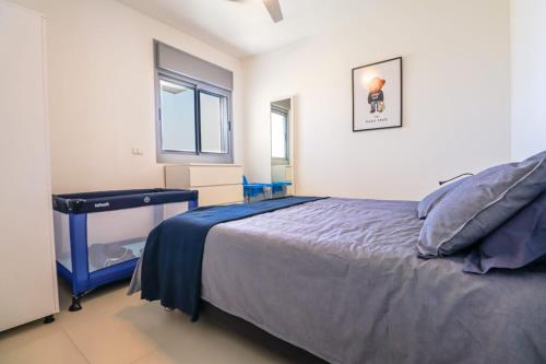 a bedroom with a bed and a desk and a window at Samson in Ashkelon