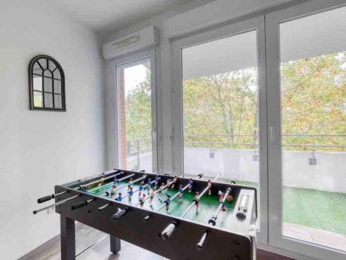 - un grand baby-foot dans une chambre avec fenêtres dans l'établissement Le Blue Dream DisneyLand Paris/ Val D’Europe, à Montévrain