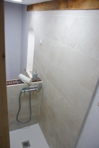 a bathroom with a shower with a hose at Casa histórica Gines in Ginés