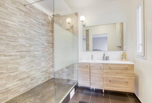 une salle de bain avec un lavabo et une douche en verre dans l'établissement Le Blue Dream DisneyLand Paris/ Val D’Europe, à Montévrain