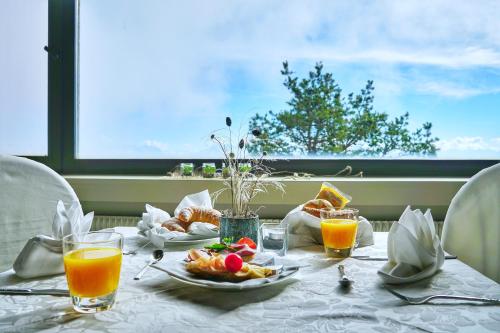 a table with breakfast food and orange juice on it at PanoramaHotel Penegal in Mendola