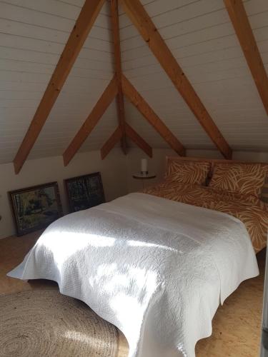 a bedroom with a white bed in a attic at De Pikeur in Deventer