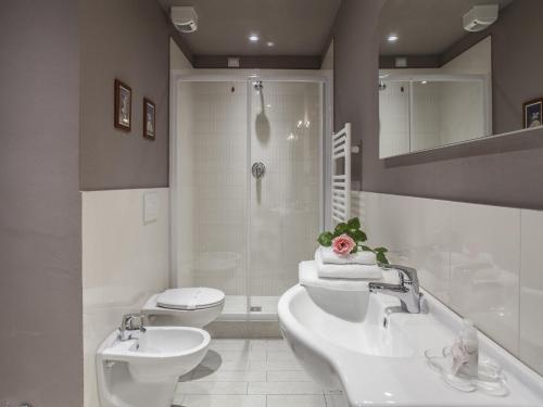 a bathroom with two sinks and a shower and a toilet at La Farina Apartments in Florence