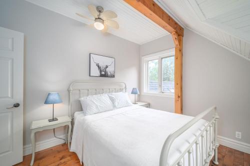 a white bedroom with a white bed and a window at Marmora Retreat - Unique Waterfront Farmhouse in Marmora