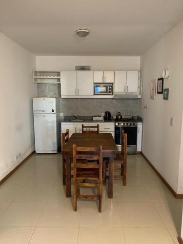 Il comprend une cuisine avec une table en bois et des appareils électroménagers blancs. dans l'établissement Apartamento Paseo Plaza Navarro, à Navarro