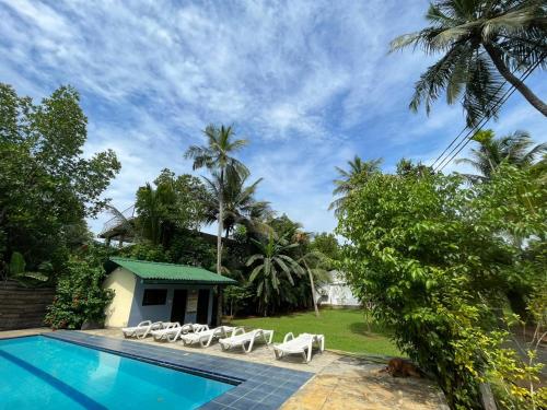a resort with a swimming pool and lounge chairs at Villa Gaetano Unawatuna in Unawatuna