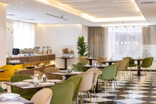 a restaurant with tables and chairs in a room at Hotel 21 in Makkah