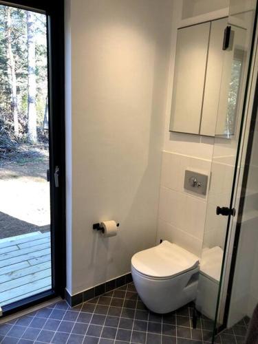 a bathroom with a toilet and a sliding glass door at Forest House, Tiidu in Nässuma