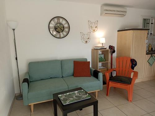 a living room with a green couch and two chairs at Gîte " Macha" classé 3 étoiles piscine Vallon Pont d'Arc in Vallon-Pont-dʼArc