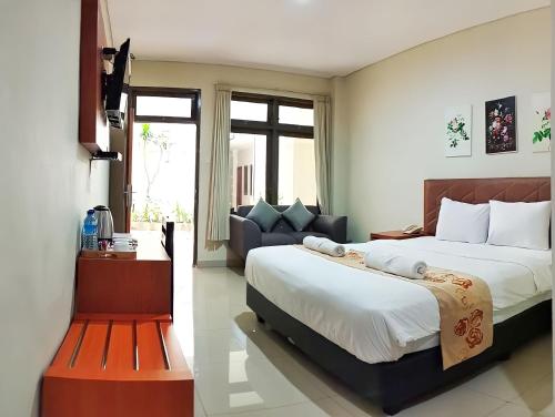 a bedroom with two beds and a couch at Lombok Mayura Hotel in Tjakranegara