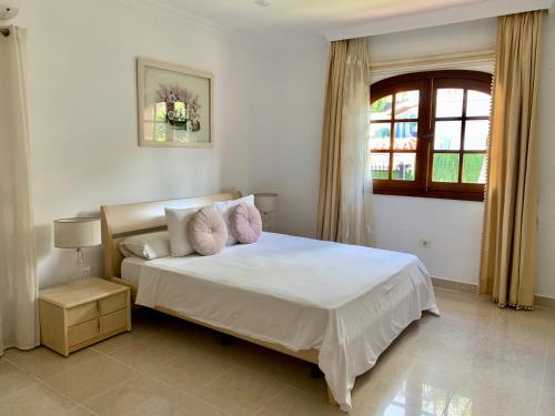 ein Schlafzimmer mit einem weißen Bett und einem Fenster in der Unterkunft Villa Claudia - HEATED POOL by VV Canary Ocean Homes in Puerto de Santiago