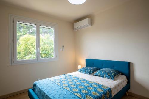 - une chambre avec un lit bleu et une fenêtre dans l'établissement Villa de 200 m2 avec piscine proche du centre-ville, à Avignon