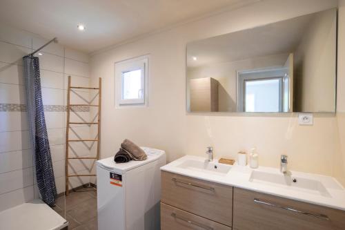La salle de bains est pourvue d'un lavabo et d'un miroir. dans l'établissement Villa de 200 m2 avec piscine proche du centre-ville, à Avignon